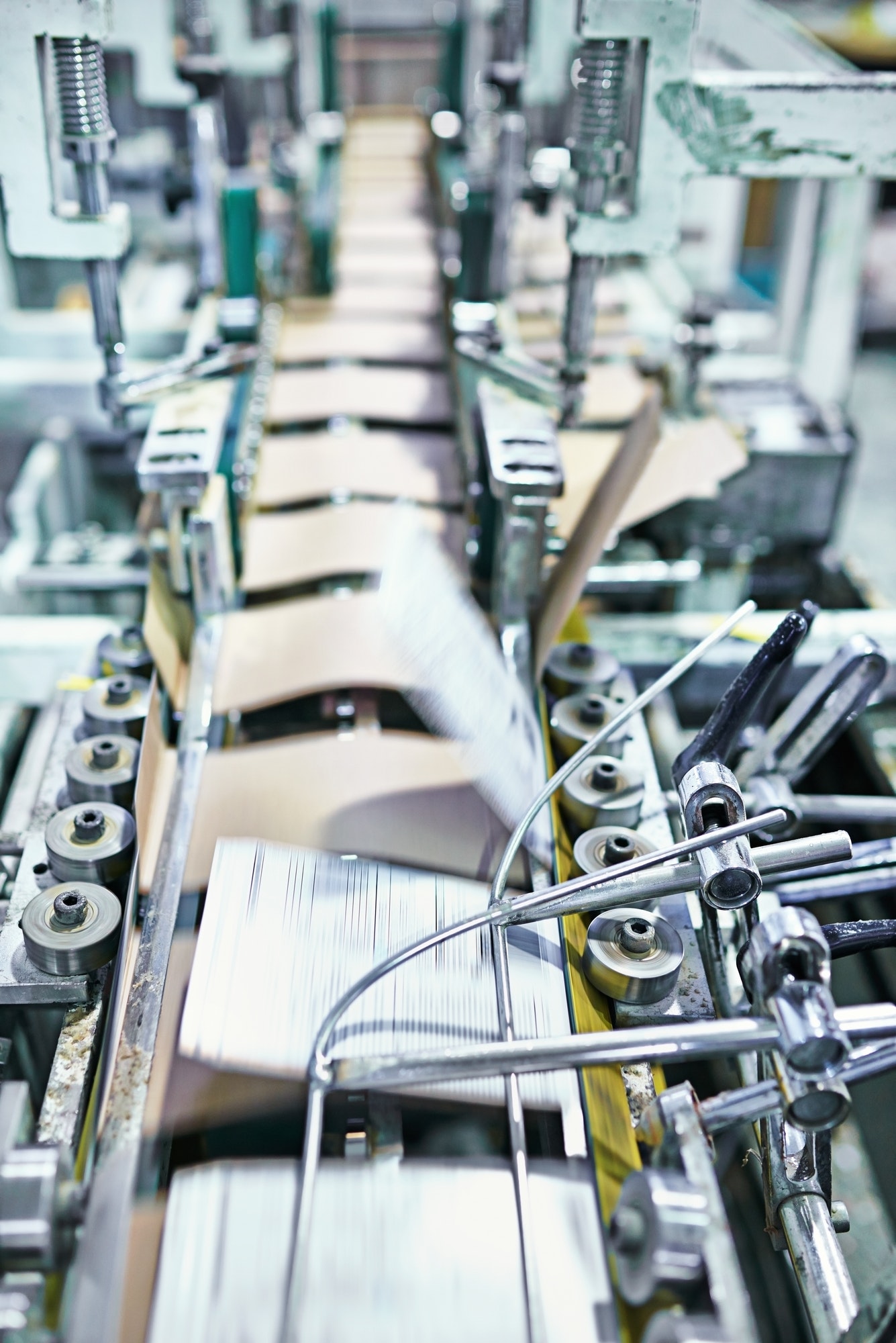 Printing automation. Detail shot of the workings of a printing factory assembly line.
